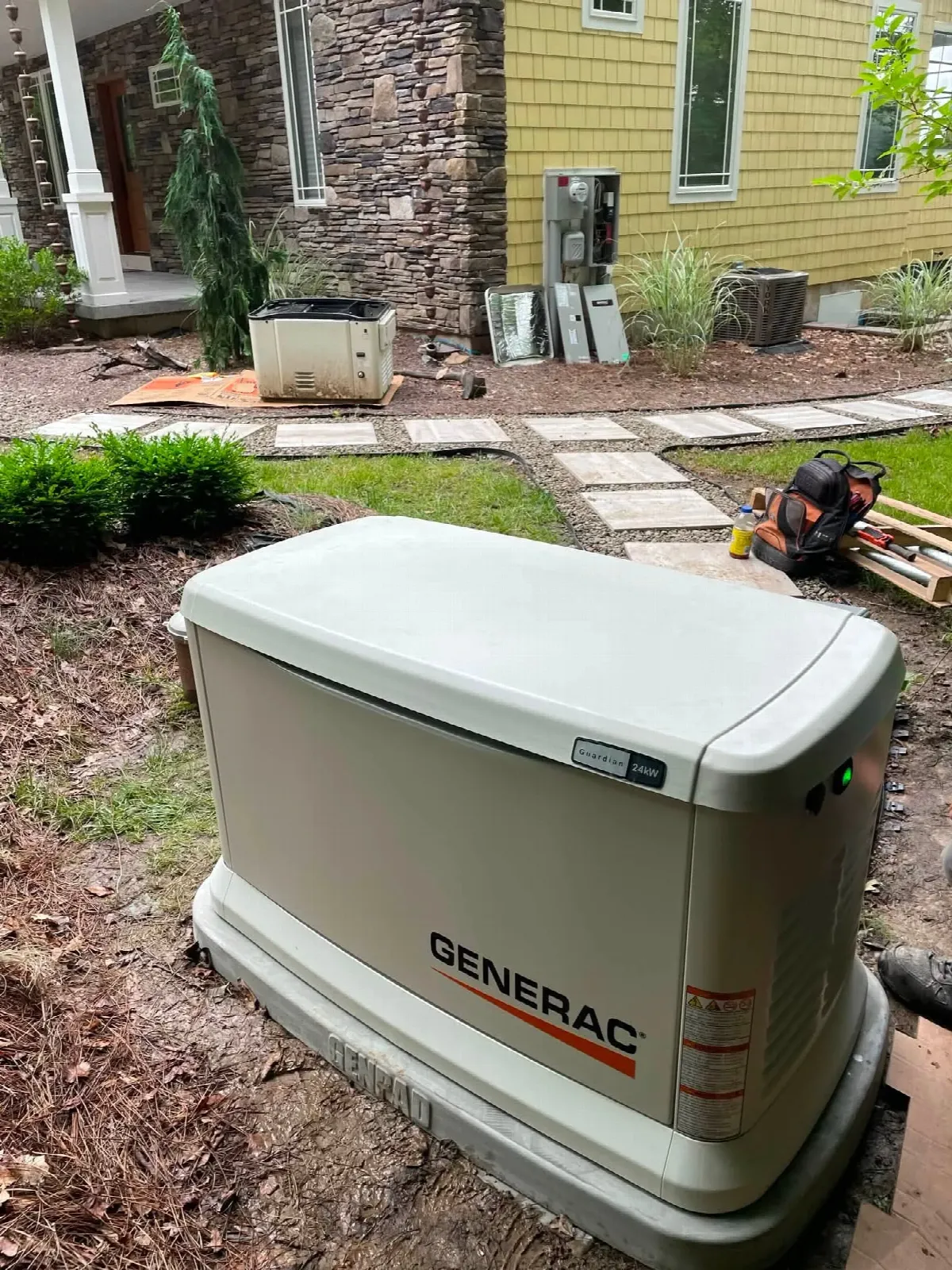Generac Guardian standby generator being installed beside a home