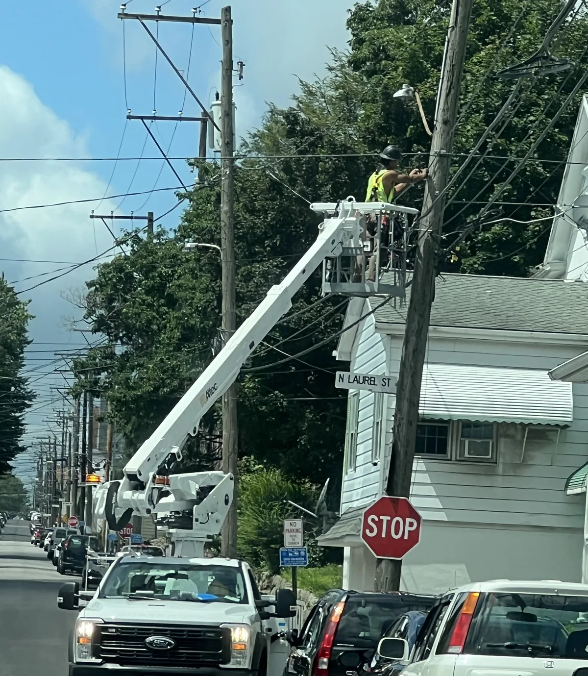 Electrician working from a bucket truck on elevated utility equipment