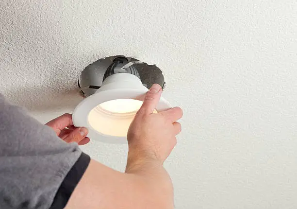 Electrician installing a recessed ceiling light